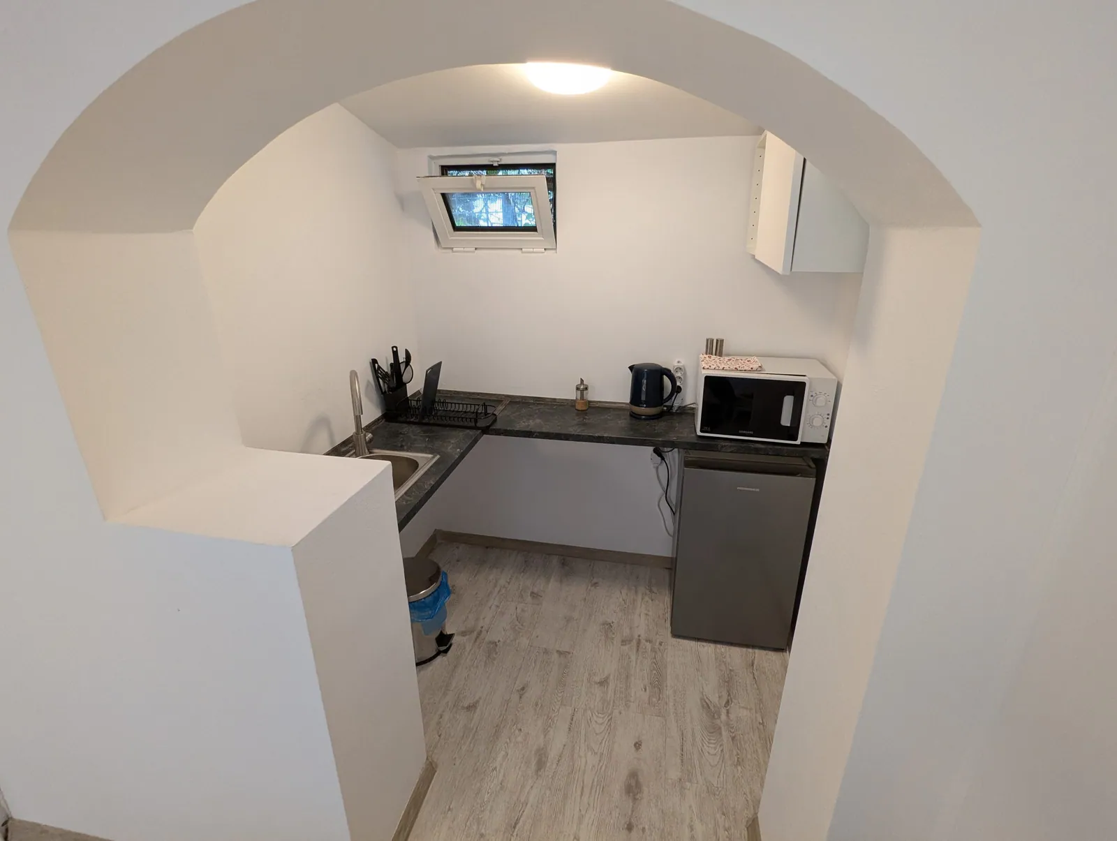 Serene Studio kitchenette with arched entrance and natural light